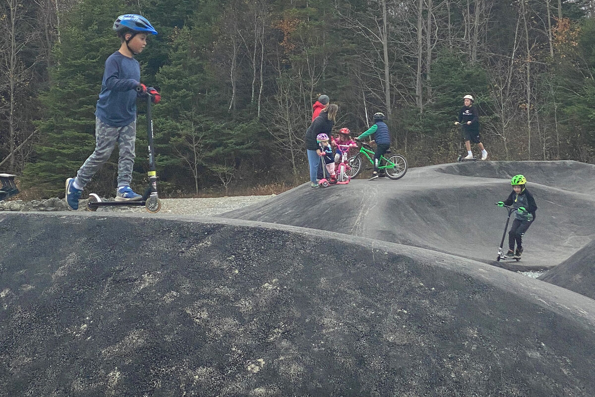 Children using a community asphalt pump track